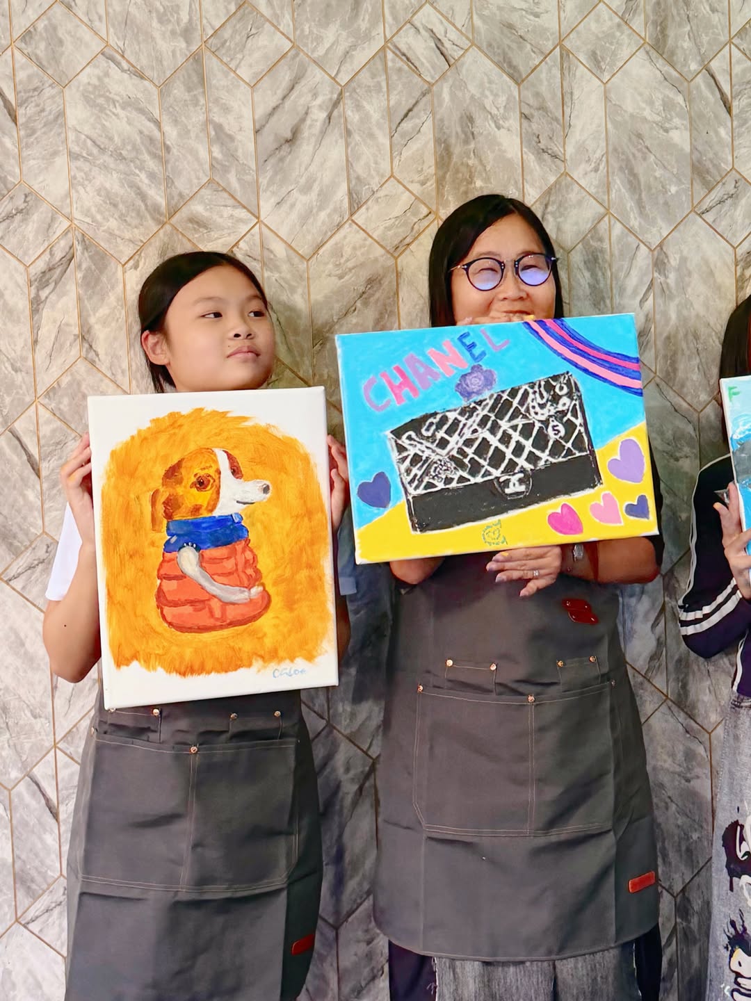 Customers proudly holding their finished paintings