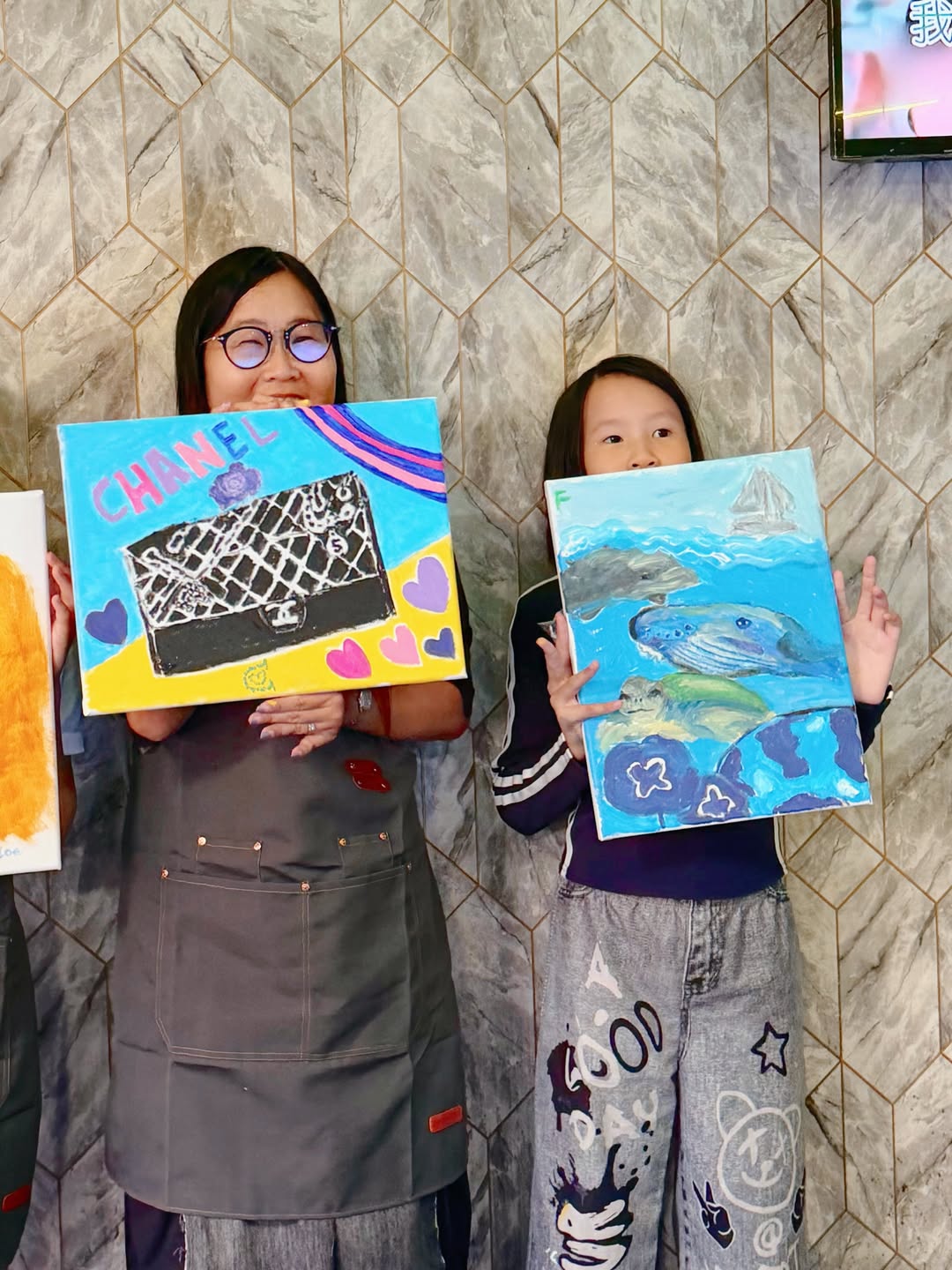 A family sharing their colourful finished artworks